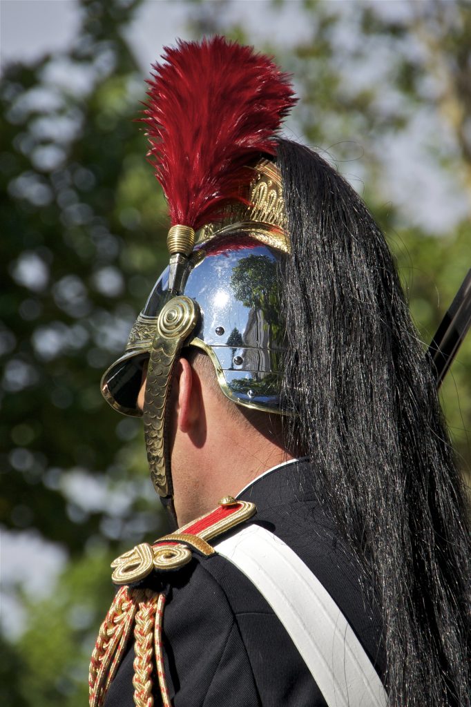 Garde républicain de dos, casque à crinière noire et plumet rouge, uniforme d'apparat