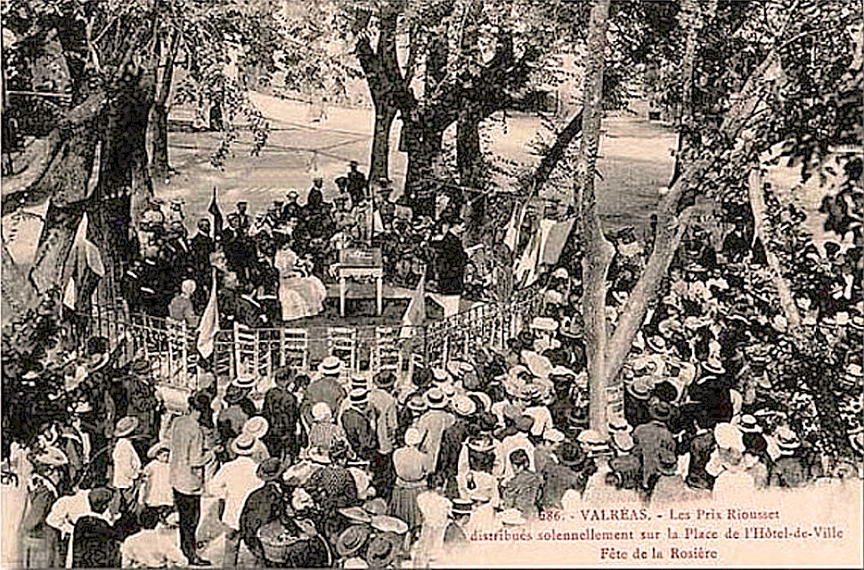 Foule en chapeaux de paille assemblée sous les arbres autour d'une estrade, carte postale ancienne
