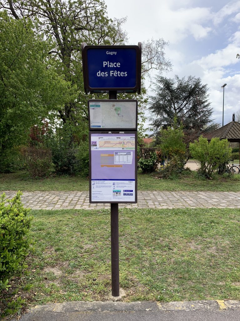 Panneau d'arrêt de bus « Gagny Place des Fêtes » avec plans, sur pelouse arborée
