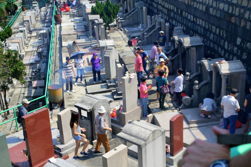 Familles nettoyant et fleurissant des tombes dans un cimetière asiatique en terrasses