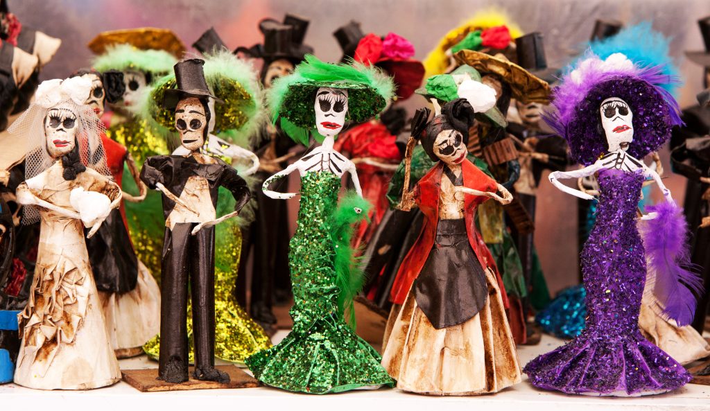 Figurines artisanales de squelettes en robes pailletées et chapeaux à plumes colorées