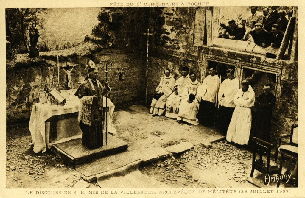 Carte postale ancienne : évêque en mitre devant un autel, clergé en aube, ruines d'abbaye